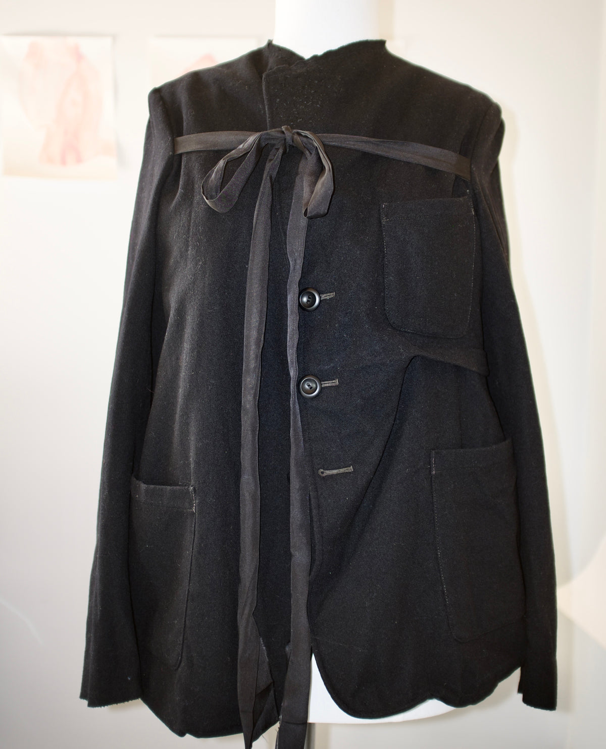Black wool deconstructed jacket with silk chest tie and hand-stitched lapel
